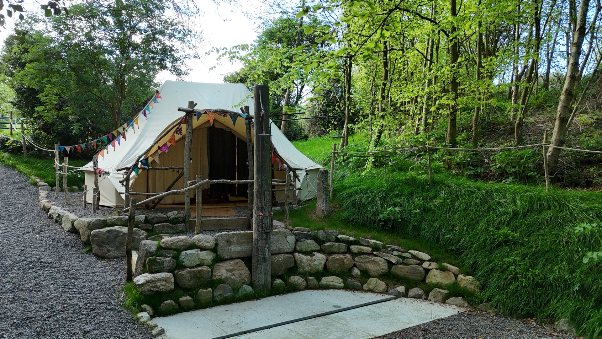 The rounded changing yurt and curved granite wall along the path